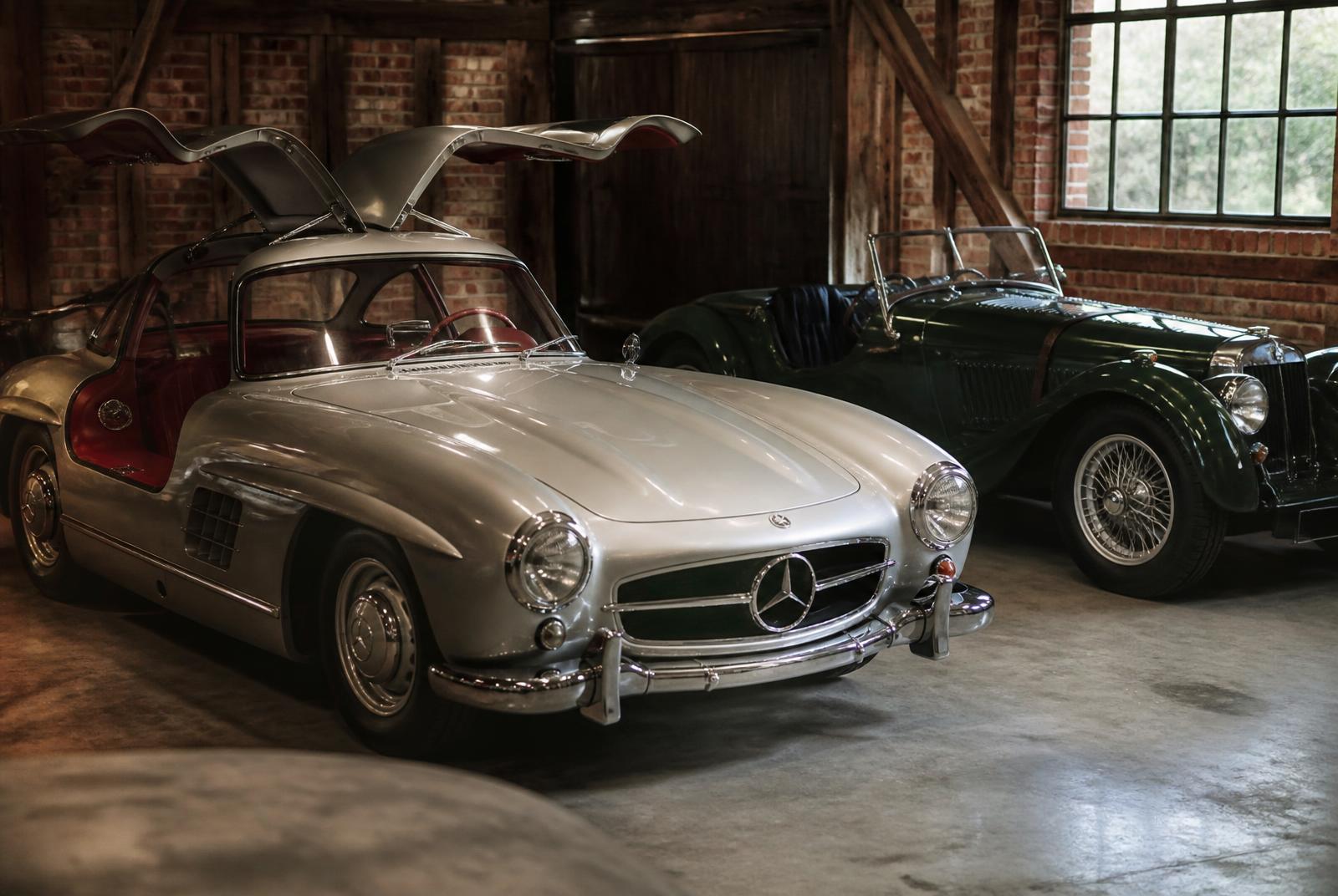 An antique collection featuring a vintage Ferrari 250 GT, Mercedes 300SL Gullwing, and Jaguar XK